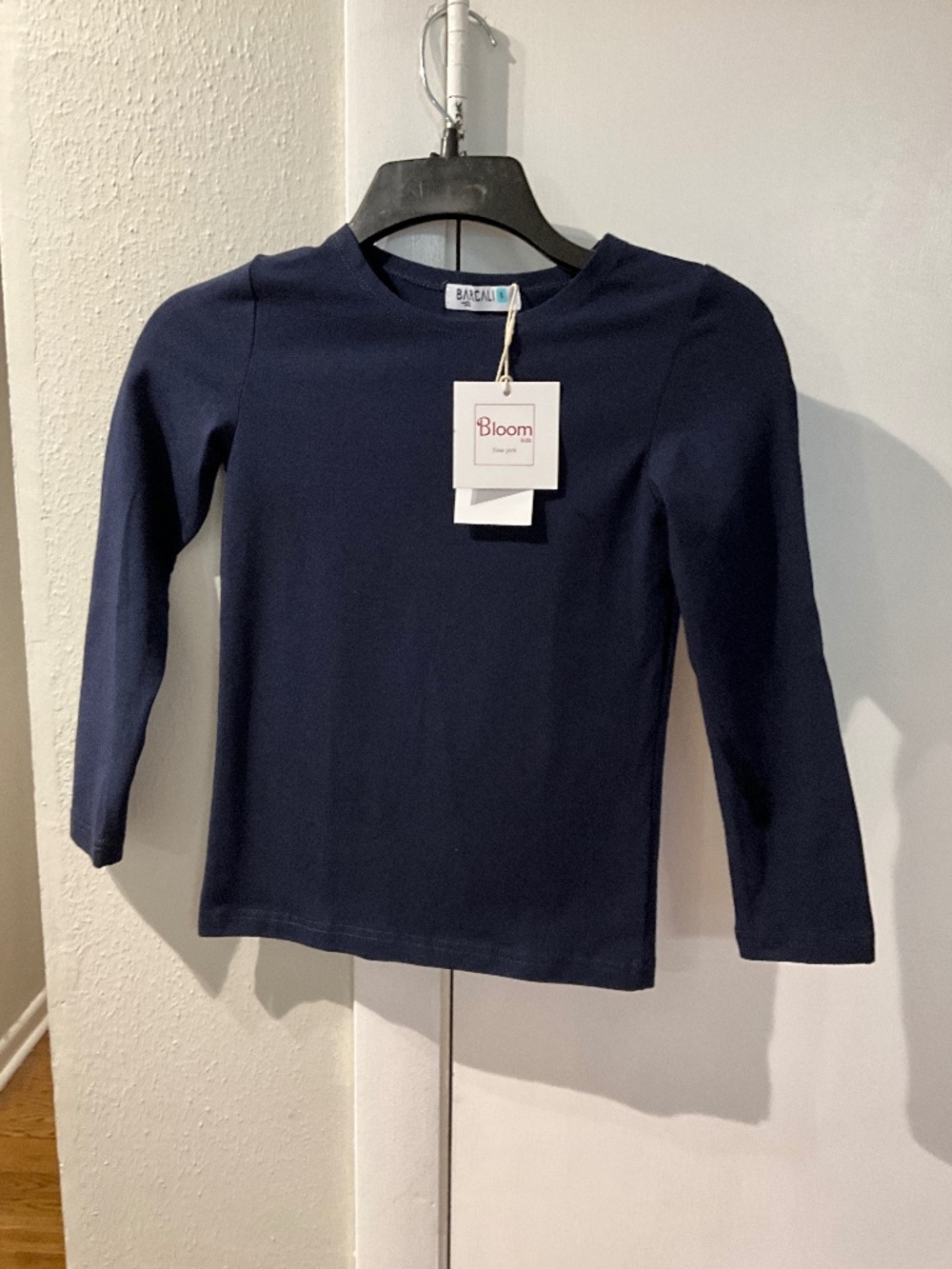 This is a Barcali Bloom Kids navy blue long-sleeve crewneck shirt.